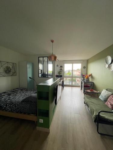 1 dormitorio con 1 cama y 1 sofá en una habitación en Studio centre ville Mont-de-Marsan en Mont-de-Marsan