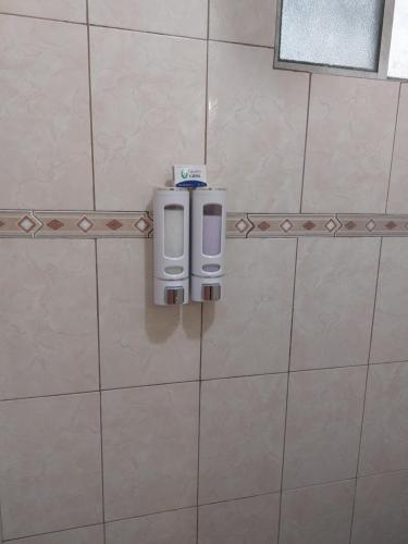 a soap dispenser on a tiled wall in a bathroom at Depto con clima y estacionamiento frente 25 IMSS in Monterrey