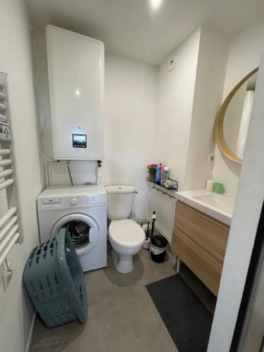 a small bathroom with a toilet and a washing machine at Studio centre ville Mont-de-Marsan in Mont-de-Marsan
