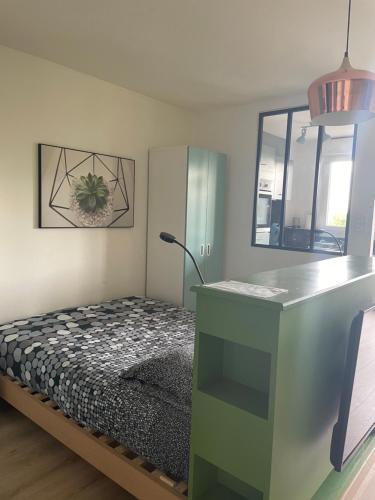 1 dormitorio con 1 cama y escritorio con lámpara en Studio centre ville Mont-de-Marsan en Mont-de-Marsan