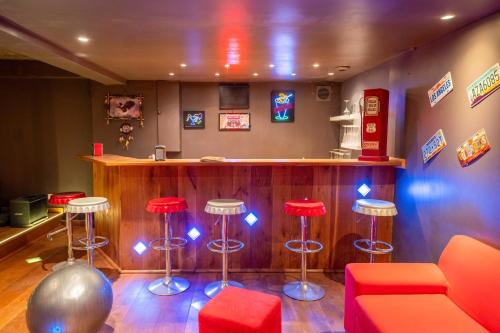 a bar with red stools and a counter at "AU HAVRE DE PAIX" 5 étoiles Prestige jacuzzi, hammam, sauna, PISCINE chauffée Mougins Cannes Grasse in Mougins