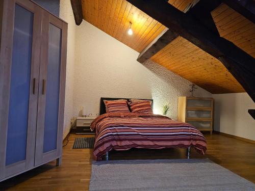 1 dormitorio con cama y techo de madera en Sady2024, en Ginebra