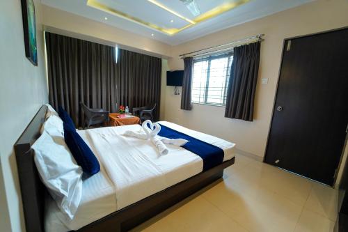 a hotel room with a bed with towels on it at Hotel Strawberry inn, Mahabaleshwar in Mahabaleshwar