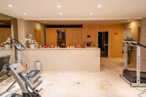 a gym with treadmills and cardio equipment in a room at "AU HAVRE DE PAIX" 5 étoiles Prestige jacuzzi, hammam, sauna, PISCINE chauffée Mougins Cannes Grasse in Mougins
