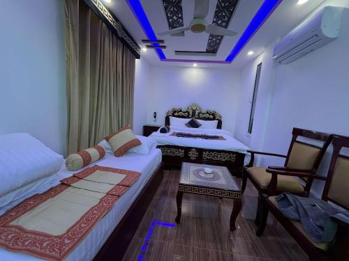 1 Schlafzimmer mit 2 Betten, einem Tisch und einem Stuhl in der Unterkunft Areesh Hotel & Restaurant in Lower Topa
