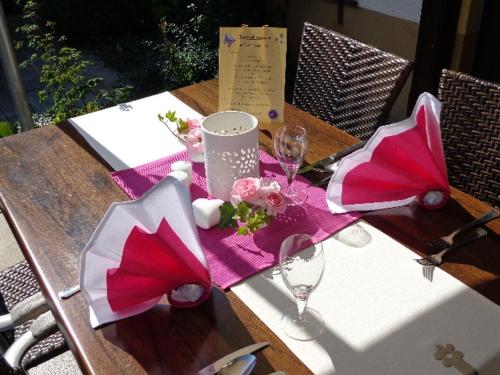 a table with pink napkins and wine glasses on it at Flair Hotel Dobrachtal in Kulmbach