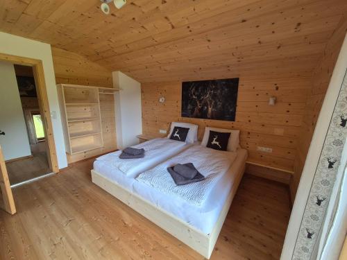 a bedroom with a large bed in a wooden room at Chalet Romana in Stumm