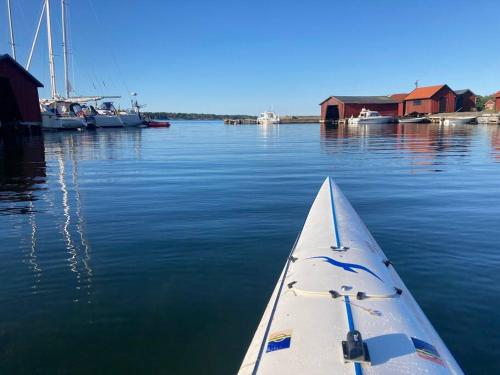 a boat sitting in the water next to a dock at Dunderfriggan på Möja in Möja