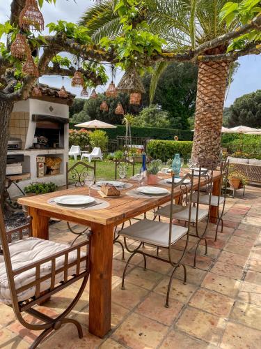 a wooden table and chairs in a yard at Villa provençale Golfe St Tropez climatisée piscine chauffée, Spa, billard, Wifi haut débit pro in Gassin