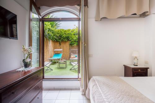 索倫托的住宿－Maison Sersale，一间卧室设有一张床,并设有一个通往庭院的开放式门。