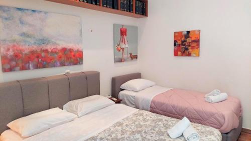 a bedroom with two beds and a painting on the wall at Lovely apartment in Athens center in Athens