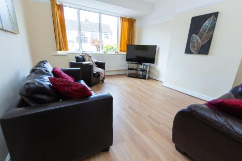 a living room with two couches and a flat screen tv at Spacious 2BR Home with Free Parking in Penwortham