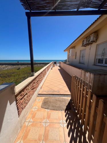 a walkway leading to a building with the ocean in the background at La Mata primera línea de playa in Torrevieja