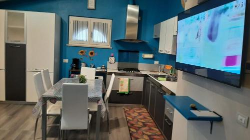eine Küche mit einem Esstisch und einem TV an der Wand in der Unterkunft CASA MARIA1 in Cigole