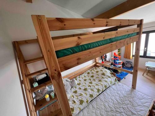 Ce lit superposé en bois se trouve dans un dortoir. dans l'établissement Charmante maison de village, à Vauvert