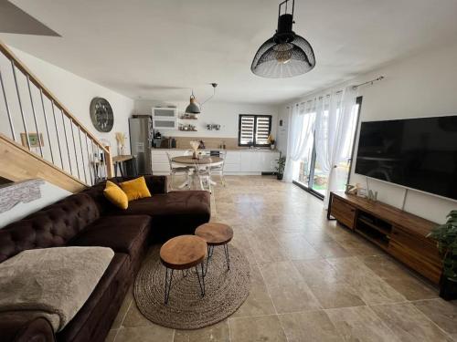 un salon avec un canapé et une télévision à écran plat dans l'établissement Charmante maison de village, à Vauvert