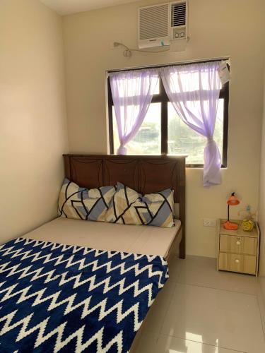 ein kleines Schlafzimmer mit einem Bett und einem Fenster in der Unterkunft 1-BR Condo unit in Mandaue City for Rent - The Midpoint Residences in Mandaue City