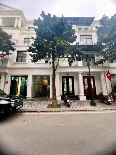 a white building with a tree in front of it at HPT Home II Vinhome Marina chuỗi Apartment - Homestay in Hai Phong