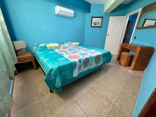 a bedroom with a bed in a blue room at Luxury condominio Tatramar in La Sabana