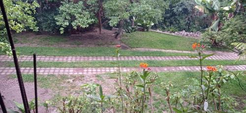 a garden with red flowers and a pathway at Country House in Los Planes. in Panchimalco