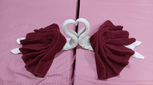 two towel swans are sitting on a bed at hotel sudhara in Tirukkadaiyūr