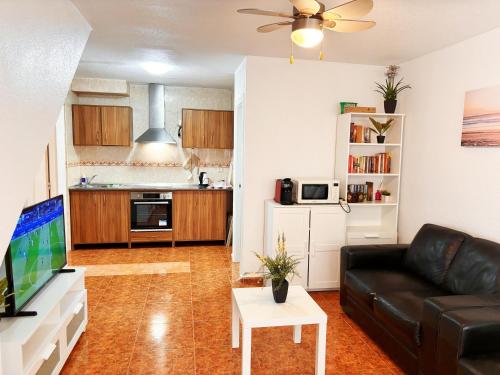 a living room with a couch and a tv at CASA JARDIN DE MAR in Torrevieja