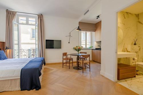 une chambre avec un lit et une table et une cuisine dans l'établissement La Guitare 24 - Nice studio in center of Cannes, just behind Grand Hotel, à Cannes