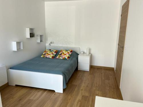 une chambre avec un lit avec deux oreillers dessus dans l'établissement Petite maison, cosy, sur les collines niçoises, à Nice