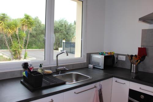 un comptoir de cuisine avec un évier et une fenêtre dans l'établissement Petite maison, cosy, sur les collines niçoises, à Nice