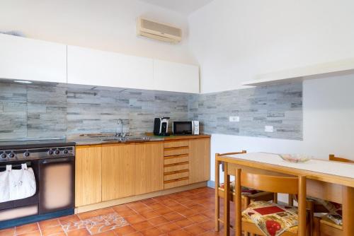 cocina con fogones, fregadero y mesa en Appartamento Terrazza, en Portoferraio