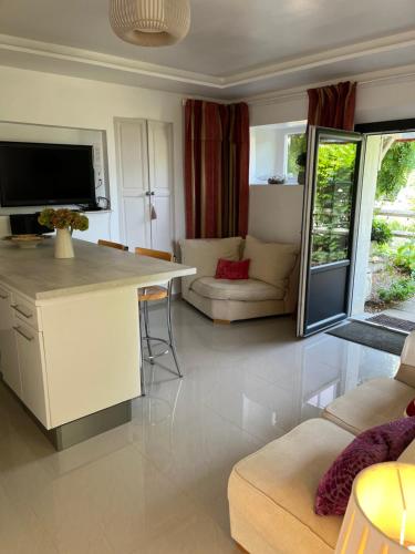 a kitchen and living room with a couch and a table at La Petite Maison in Corme-Écluse