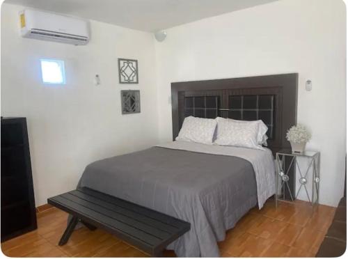 a bedroom with a bed with a bench next to it at Bonito apartamento Wifi alta, Minisplit in Chihuahua