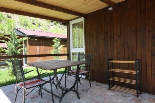 a table and chairs on a patio with a window at Lugina e Shengjergjit ,Bujtinat in Tirana
