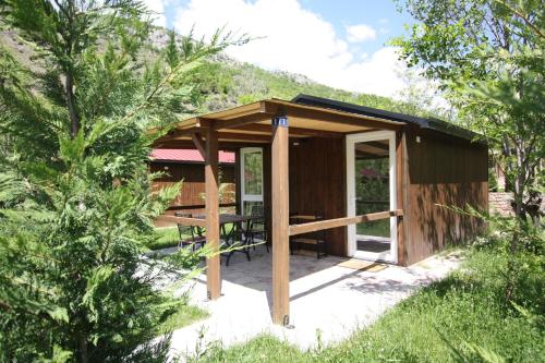 a wooden cabin with a picnic table in the woods at Lugina e Shengjergjit ,Bujtinat in Tirana