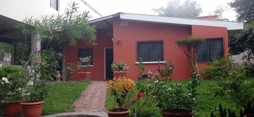 a red house with plants in front of it at Country House in Los Planes. in Panchimalco