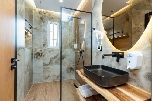 uma casa de banho com um lavatório e um chuveiro em Hotel Joni em Ksamil