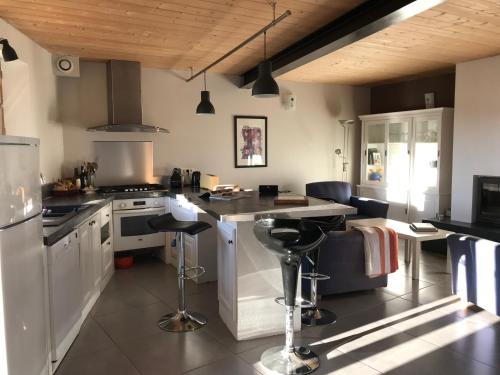 a kitchen with a stove and a counter with stools at Grande maison de vacances - Montagne Pyrénées in Planès