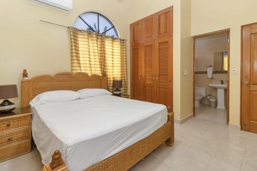 1 Schlafzimmer mit einem großen Bett und einem Badezimmer in der Unterkunft Awesome Villa in THE CENTER of Sosua - Near Everything in Sosúa