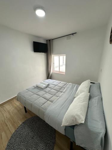 a large bed in a room with a window at Rooms Getafe in Getafe