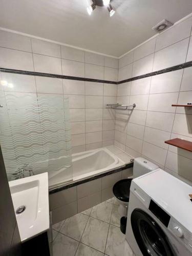 La salle de bains est pourvue d'une baignoire, d'un lavabo et d'un lave-linge. dans l'établissement L'ORFÈVRE - hypercentre, lumineux, vue cathédrale, à Blois