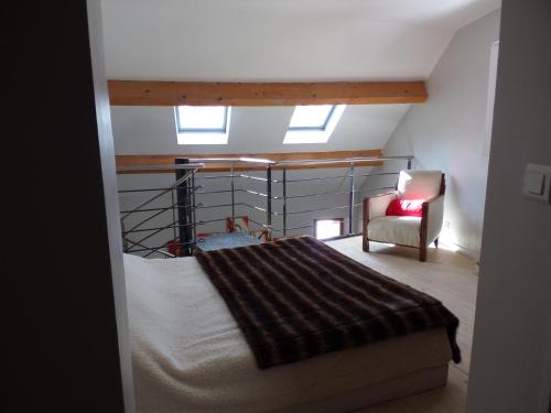 a attic room with a bed and a chair at Grande maison de vacances - Montagne Pyrénées in Planès