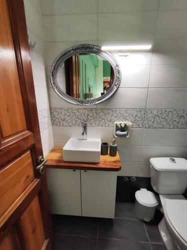 a bathroom with a sink and a mirror and a toilet at Electra's Seaside in Agios Georgios