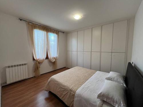 a bedroom with a large bed and two windows at Il nido dell'abete in Borgo a Buggiano
