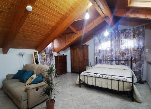 um quarto com uma cama e um sofá num quarto em Orto del pettirosso em Front