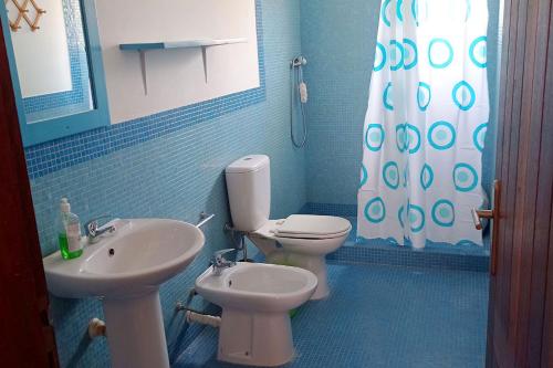 a blue bathroom with a toilet and a sink at Appartamento Ferreira Stella Maris Exclusive in Calheta Do Maio