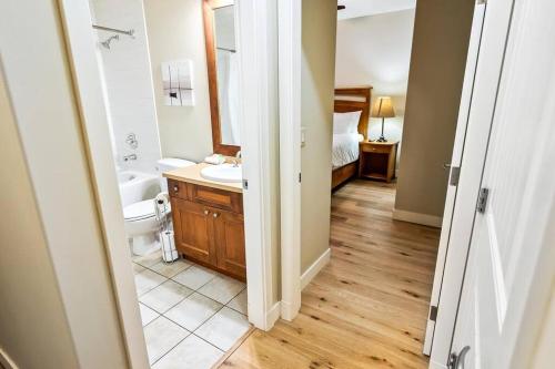 y baño con lavabo, aseo y espejo. en Spacious 3 Bedroom at Barona Beach #5101, en West Kelowna