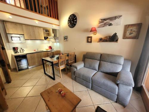un salon avec un canapé et une table dans l'établissement Appartement rénové 2 pièces + mezzanine, centre Les Gets, parking - FR-1-598-77, aux Gets