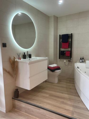 une salle de bain avec un lavabo, une baignoire et un miroir dans l'établissement La suite Tournonaise, à Tournon-sur-Rhône