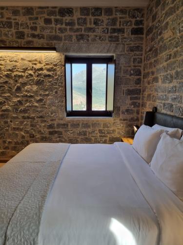 a bedroom with a bed and a brick wall at Manifest Boutique Hotel in Oítilon