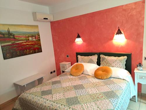 a bedroom with a bed with a red wall at Florivana Boutique Hotel Ristorante in San Pietro in Cariano